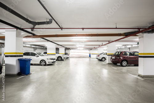 Underground parking lot, interior with a few parked cars.