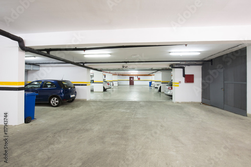 Underground parking lot, interior with a few parked cars.