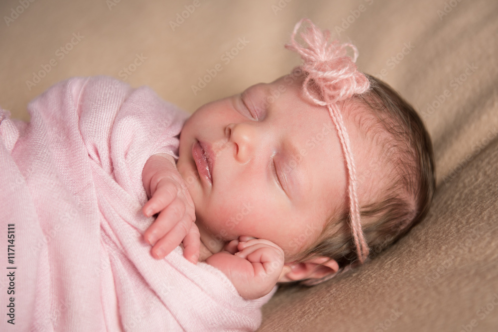 Newborn baby sleeps under a knitted pink cape. Close-up Newborn baby sleeps under a knitted pink cape. Close-up