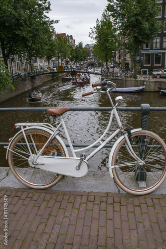 On white bike on the pavement near canals in Amsterdam