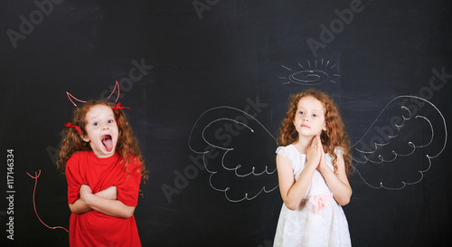 Foto Angry girl with imp horns and tail and a angel girl wings drawn