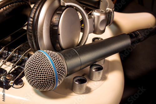microphone and headphone on white electric bass by music instrument.