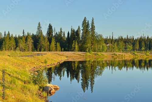 Evening. Coastline of northern lake and reflection. Lapland, Finland photo