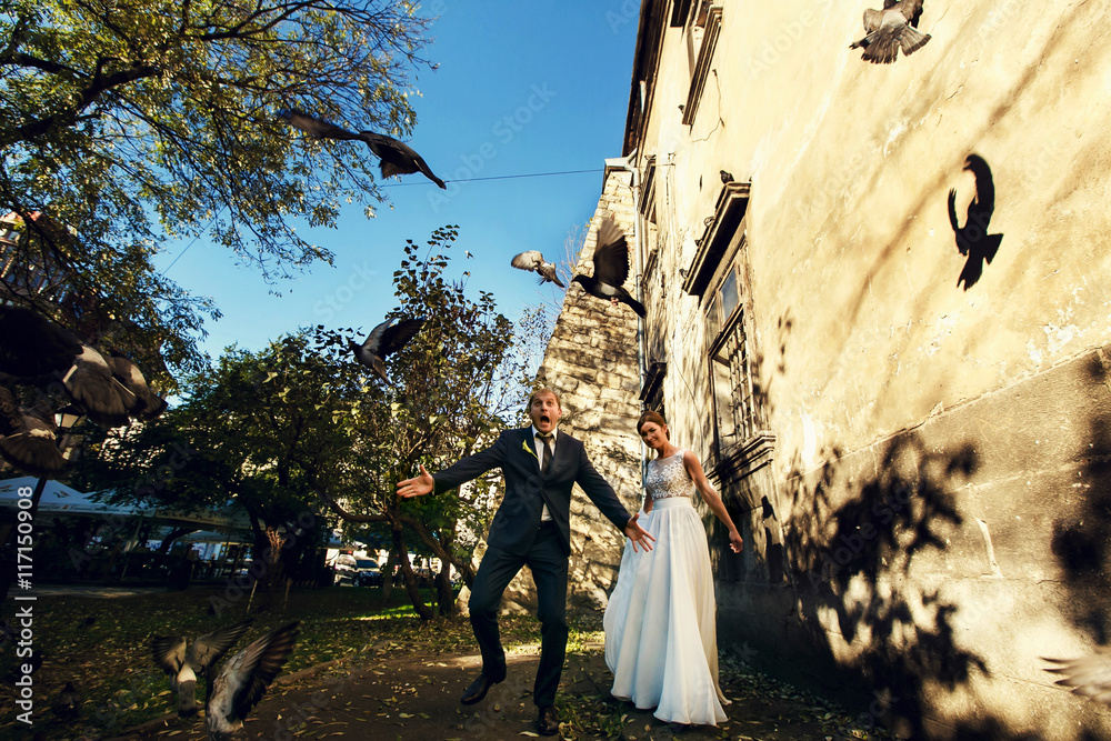 Groom looks funny dispersing the pigeons