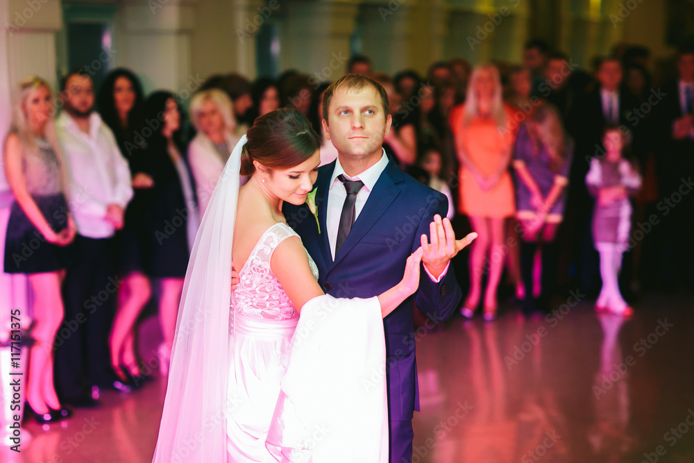 Groom holds a delicate bride tenderly during their first dance