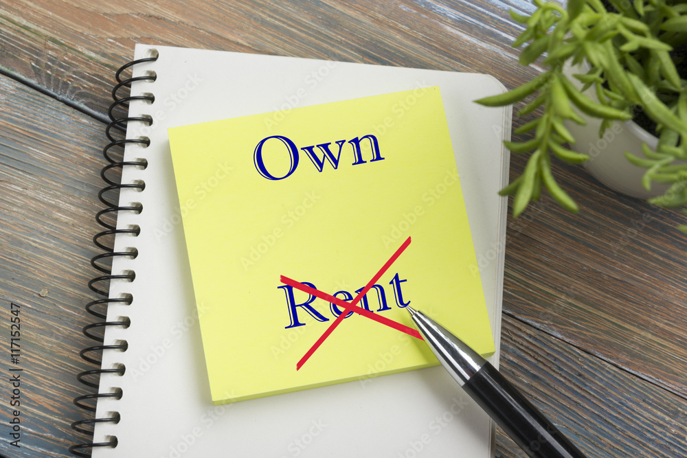 Real estate concept. Notepad with buy or rent message, pen and flower. Office supplies on desk table top view Real estate concept. Notepad with buy or rent message, pen and flower. Office supplies on desk table top view