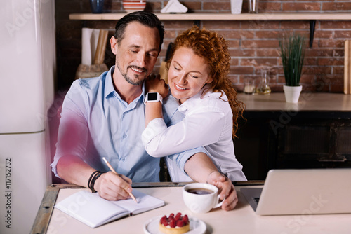 Woman looking how man writing