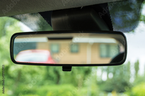 Rear-view mirror in a car in green environment in UK residential area