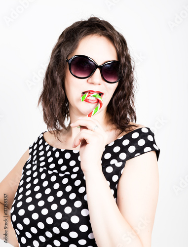Portrait of happy beautiful young woman licking sweet candy and expressing different emotions. pretty woman with heart shaped lollipop