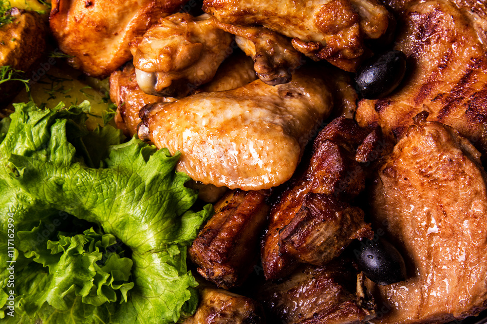Grilled chicken wings and legs with lettuce and black olives