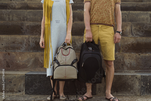 Concept traveling together, honeymoon. Stylish couple in love with backpacks standing on footstep
