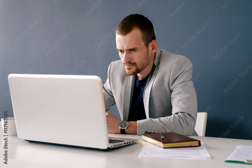 Office worker in suit working on laptop Office worker in suit working on laptop