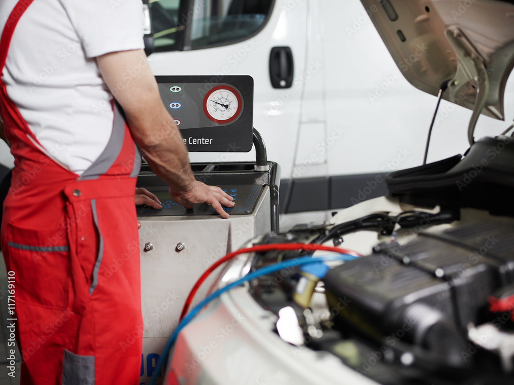 Car mechanic checks the air handling unit of a car Car mechanic checks the air handling unit of a car