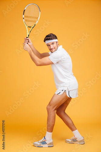 Full length of attractive man player standing and playing tennis © Drobot Dean