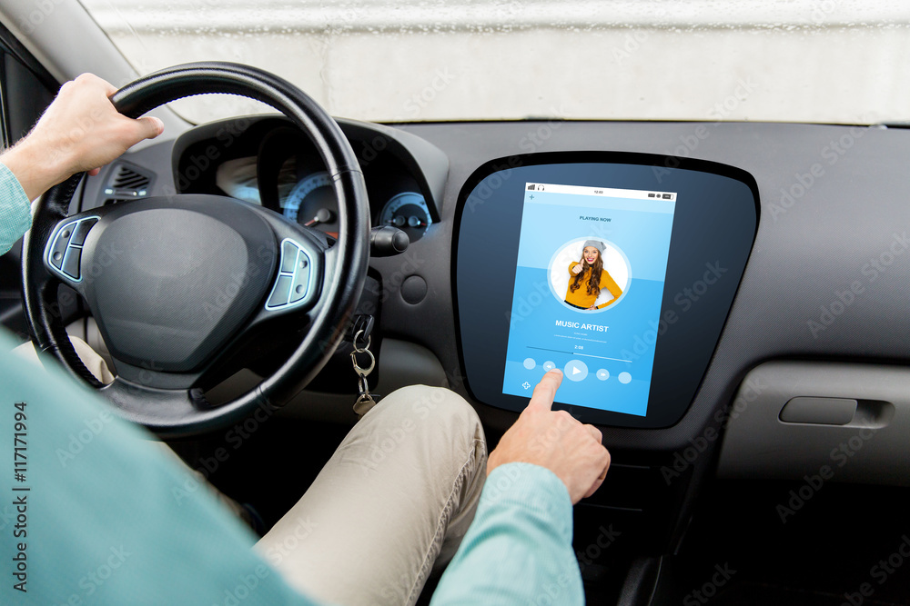 man driving car with music on board computer