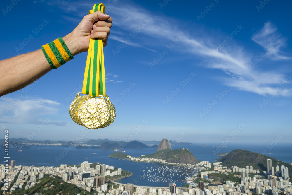 Φωτογραφία Hand of first place athlete with Brazil colors wristband holding gold medals at
