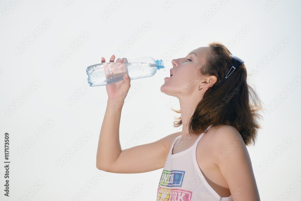 Beautiful young woman drinking water