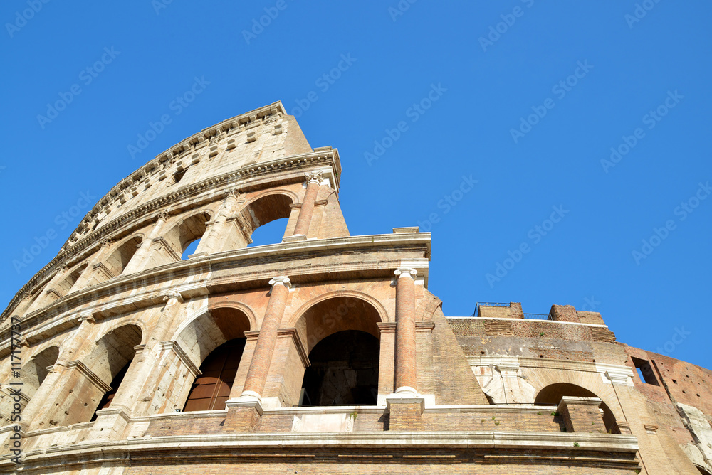 Flavian Amphitheatre or Colosseum in Rome with blue sky in the background, Italy