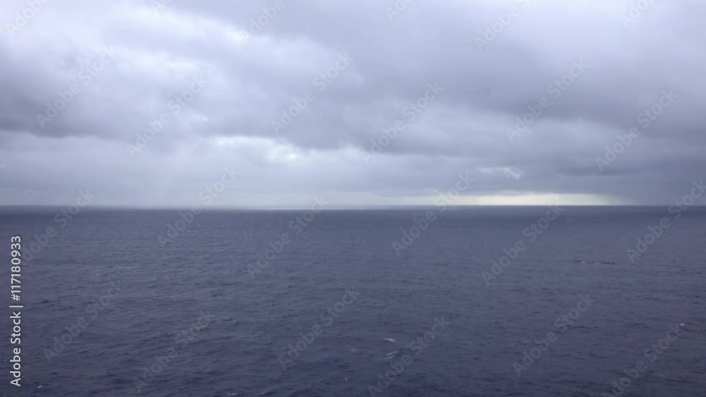 Caribbean Ocean storm clouds on horizon. Sunset over Caribbean Ocean from moving ship. Beautiful sunset over Caribbean Ocean from cruise ship vacation. Smooth sea water and vibrant colorful clouds. Caribbean Ocean storm clouds on horizon. Sunset over Caribbean Ocean from moving ship. Beautiful sunset over Caribbean Ocean from cruise ship vacation. Smooth sea water and vibrant colorful clouds.