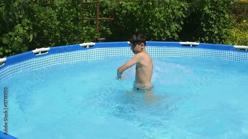 Swimming pool. Young boy playing with water in the pool. Slow motion. HD