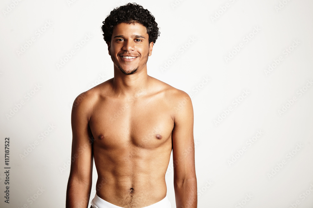 Fototapeta premium young smiling man topless on a white wall