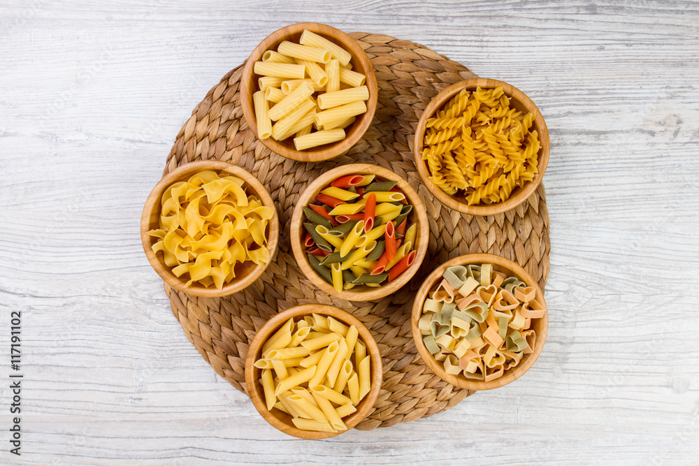 Various combinations of pasta on wooden background, burlap bags, bamboo bowls. diet and nutritional concept. Various combinations of pasta on wooden background, burlap bags, bamboo bowls. diet and nutritional concept.