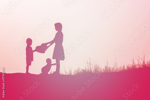 Mother encouraged her son outdoors at sunset, silhouette concept