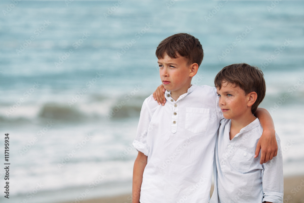 Portrait of happy brothers in white shirts on background of sea Portrait of happy brothers in white shirts on background of sea