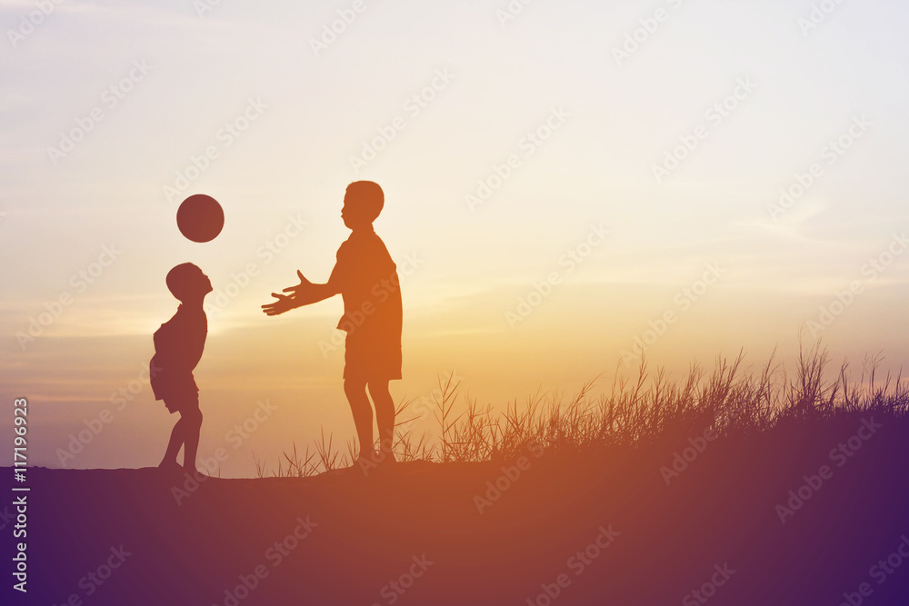 children playing ball on meadow, sunset, summertime
