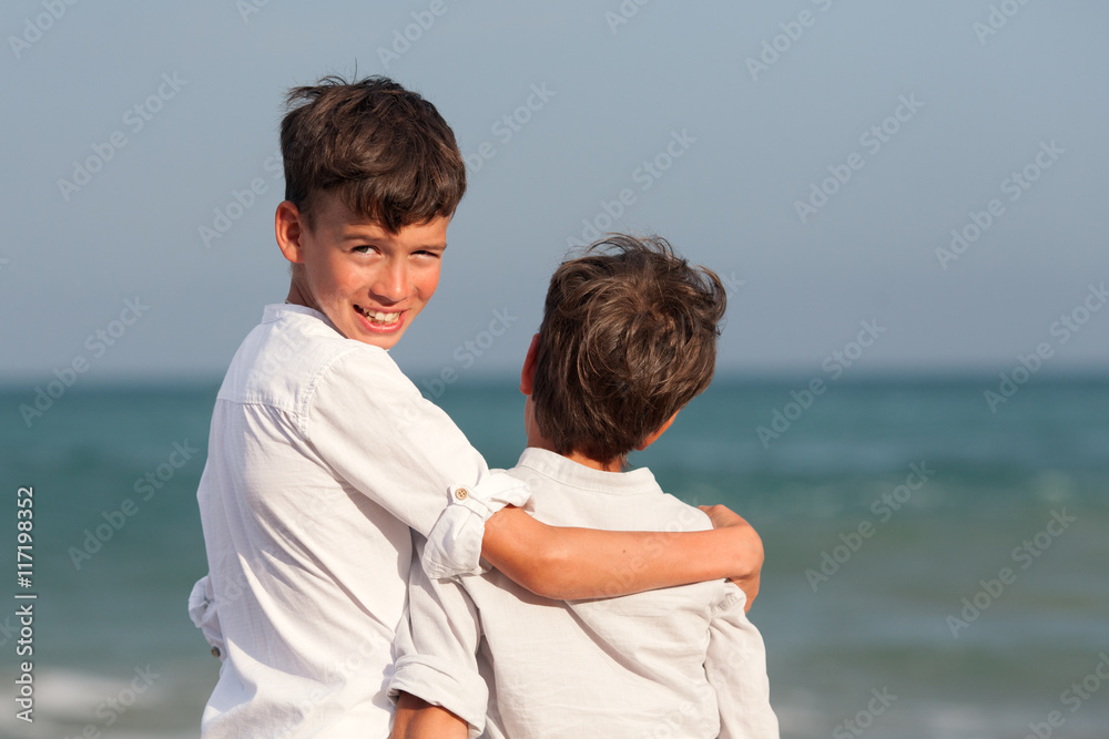 Portrait of happy brothers in white shirts on background of sea Portrait of happy brothers in white shirts on background of sea