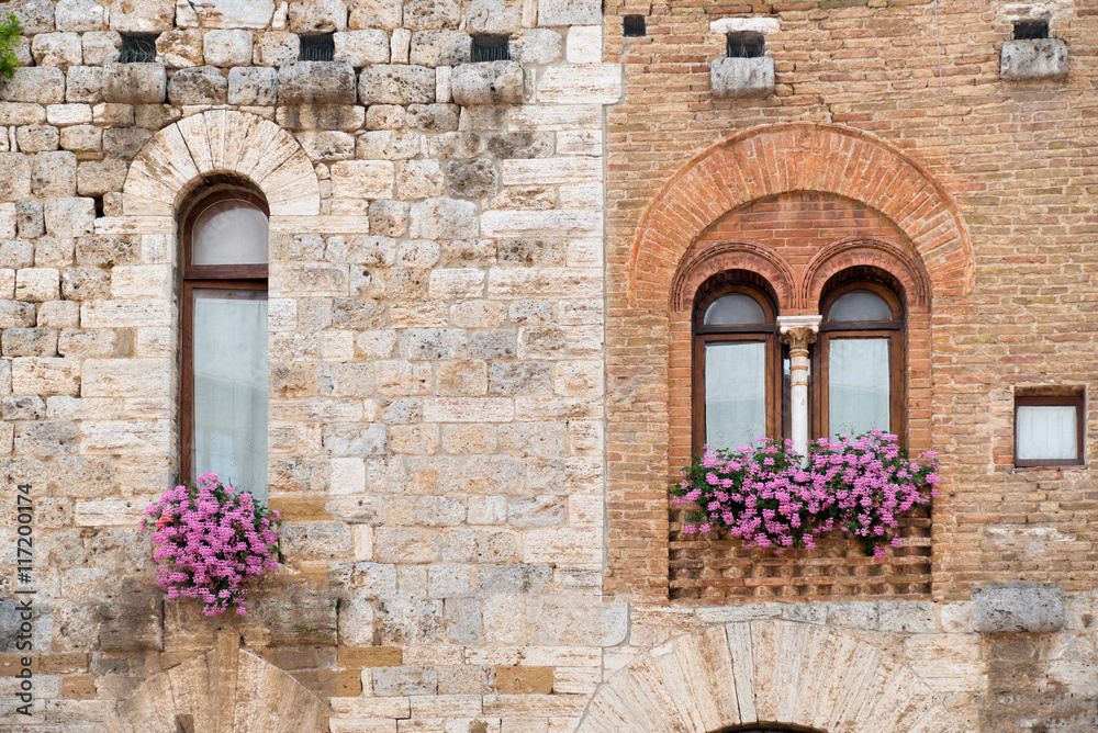 Two ancient windows in the medieval truscan town San Gimignano.