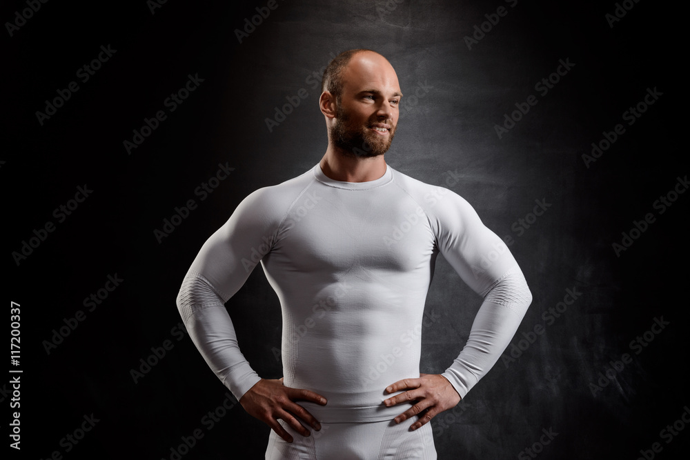 Young powerful sportsman in white clothing over black background. Young powerful sportsman in white clothing over black background.