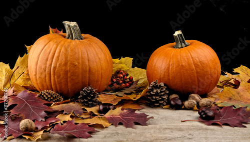 Pumpkins with autumn leaves for thanksgiving day on black backgr