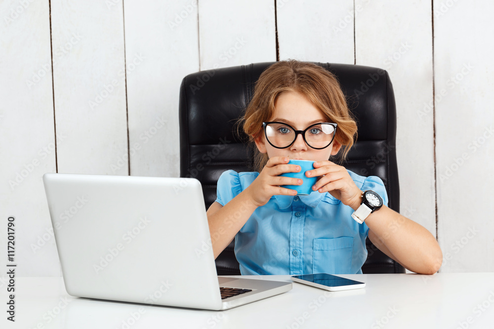 Young beautiful girl sitting at working place in office.