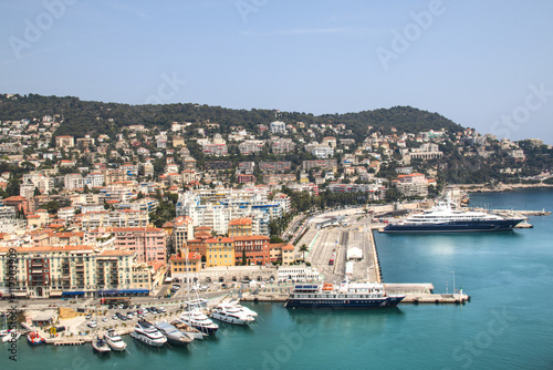 The harbor of Nice in France with some boats, seen from above from behind the cactus trees 