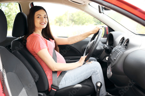 Pregnant woman driving car. Safety drive concept