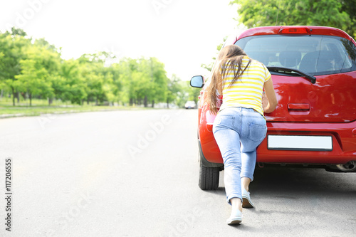 Woman pushing red car