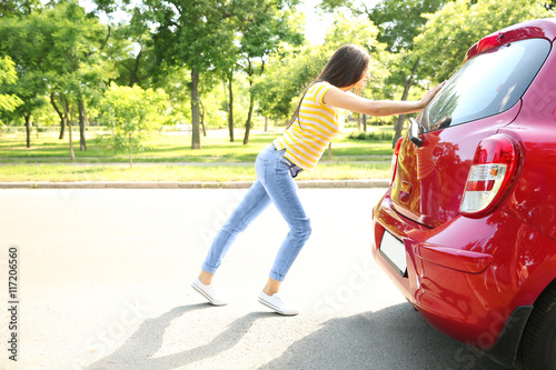 Woman pushing red car