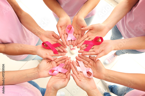 Obraz na płótnie Female hands holding pink ribbons. Breast cancer concept