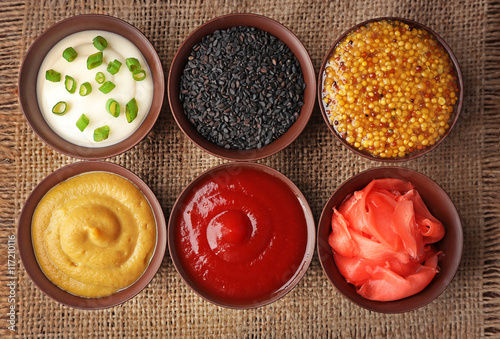 Slika na platnu Fresh condiments and sauces on sackcloth napkin