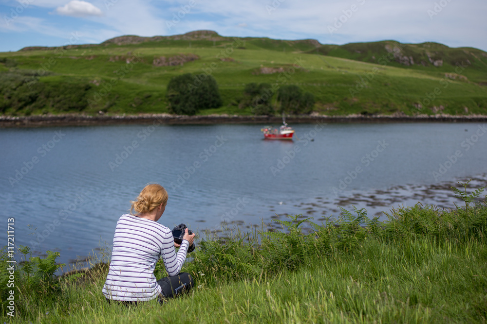 Young female photographer taking pictures at the coast of Scotland Young female photographer taking pictures at the coast of Scotland