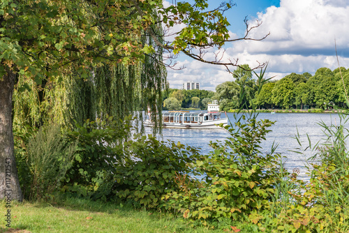 Alster Lake in Hamburg Germany on a summer day. View at beautiful and famous city park Alsterwiese, located in the center of the Hansestadt Hamburg, image for travel concept