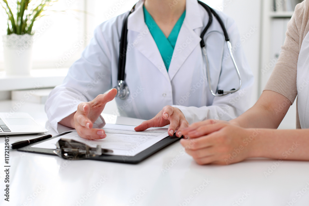 Doctor and patient are discussing something, just hands at the table Doctor and patient are discussing something, just hands at the table