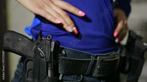 young woman with the gun on an indoor shooting range. collect gun
