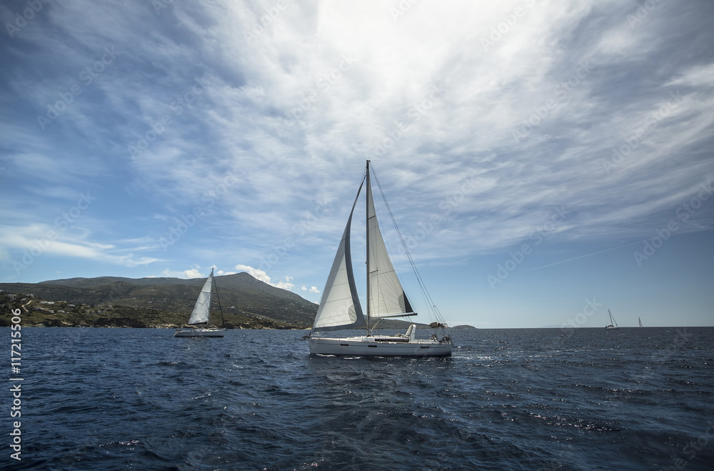Obraz premium Beautiful yacht sailing on the sea near the island.
