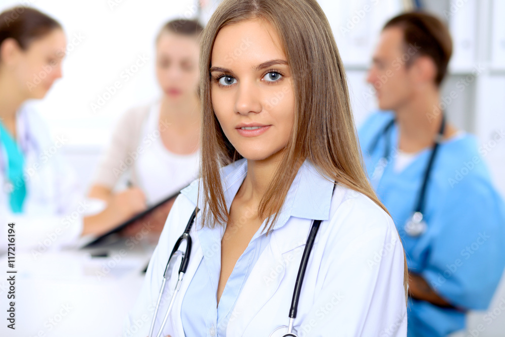 Happy doctor woman with medical staff at the hospital sitting at the table and discussing medical history Happy doctor woman with medical staff at the hospital sitting at the table and discussing medical history
