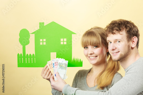 Wife and husband holds paper house.