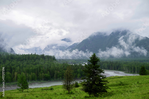 mountain landscape in the fog and the clouds to the river