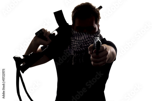 Canvas Print Ambiguous silhouette of a terrorist or a soldier with a rifle and a handgun