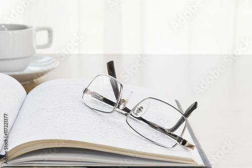  Eyeglasses put on a book with on the desk